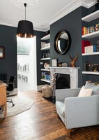 Black painted walls and white shelving in modern living room 