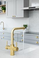 Modern kitchen sink with gold running tap