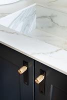 White marble sink and black cupboard in modern kitchen 