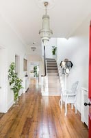 Large white painted entrance hall with wooden floorboards 