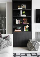 Black bookcase in black and white living room 