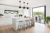 Modern kitchen with view through patio doors to barbecue area on terrace