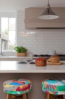 Colourful barstools in neutrally decorated modern kitchen 
