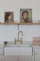 Painted portraits on shelf above butler sink 