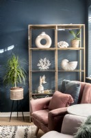 Gold shelving with display of white objects against dark wall