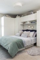 Modern bedroom with built-in units around bed