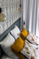 Detail of pillows and cushions on bed in modern bedroom