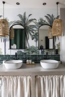 Twin sinks in modern bathroom with tropical mural on wall