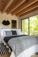 Modern country bedroom with view to gardens through patio doors