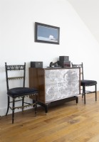 Antique chairs and vintage chest of drawers in modern bedroom