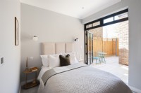 Modern bedroom with doors on to patio terrace