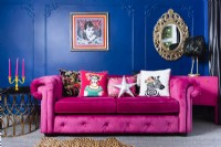 Pink sofa against a blue living room wall