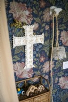 Decorative fabric cross on wallpapered wall - detail