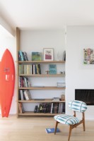 Wooden bookshelf and surf board in modern living area 