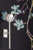 White lotus shaped wall light on featured painted wall with lotus flowers.