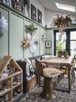 Rustic Scandinavian dining room with table and Christmas decorations and dolls house