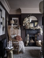 Bohemian living room with peacock chair,ornate fireplace  with mantle dressing