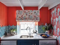 Sea inspired ornaments, tiles, blinds and wallpaper in a colourful kitchen