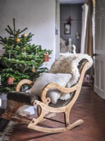 Rustic rocking armchair next to Christmas tree