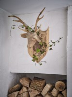 Wooden deer sculpture wrapped in a garland