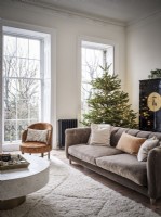 Large grey sofa and cream rug in front of Christmas tree