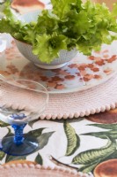 Detail of salad bowl, vintage plate and patterned tablecloth