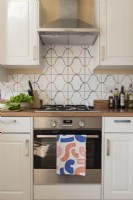 Detail of cooker with extractor fan and patterned tiling