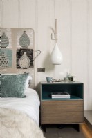 Detail of patterned headboard and bedside table in modern bedroom