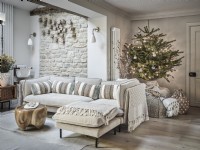 Seating area in neutral tones featuring Christmas tree and gifts