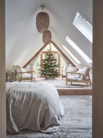 View into bedroom with neutral tones and Christmas tree