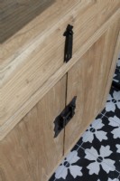 Detail of vanity unit, black hardware and black and white tiles