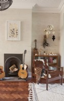 View of a fireplace in a living room with eclectic vintage furniture and accessories. 