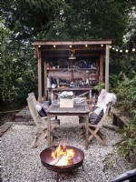 Outdoor dining area featuring fire pit and retro kitchen space