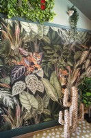 Colourful jungle themed wallpaper feature wall with straw cactus