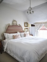 Pink and white bedroom with ornate headboard