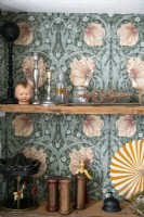 Detail of ornaments on shelves with patterned wallpaper backing