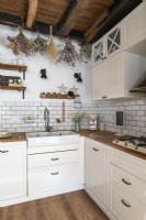 Dried flowers hanging from beams in country kitchen