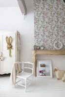 White chair and painted floorboards in childs country bedroom