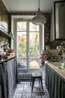 Small galley kitchen with fabric skirting and large windows