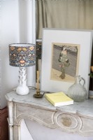 Artwork and decorative lamp on mantelpiece 