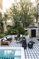 Checkerboard paving on terrace with seating area and pool