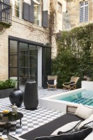 Swimming pool and seating areas on checked paving