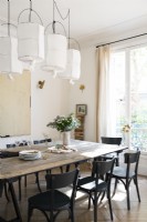 Large wooden table with black chairs in white dining room