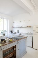Distressed wooden island in modern kitchen with Smeg fridge-freezer 