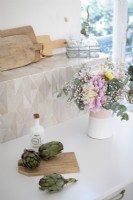 Flower arrangment and vegetables on kitchen worktop - detail
