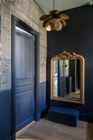 Dark blue hallway with gold accessories 