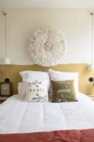 Modern bedroom with embroidered cushions and fabric wall art