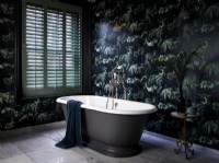Luxurious bathroom with patterned wallpaper and green shutters