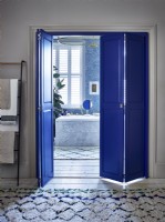 En suite bathroom with blue shutters in dividing doorway