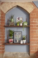 Bedroom detail showing original exposed brickwork, open shelving for plants and ornaments.